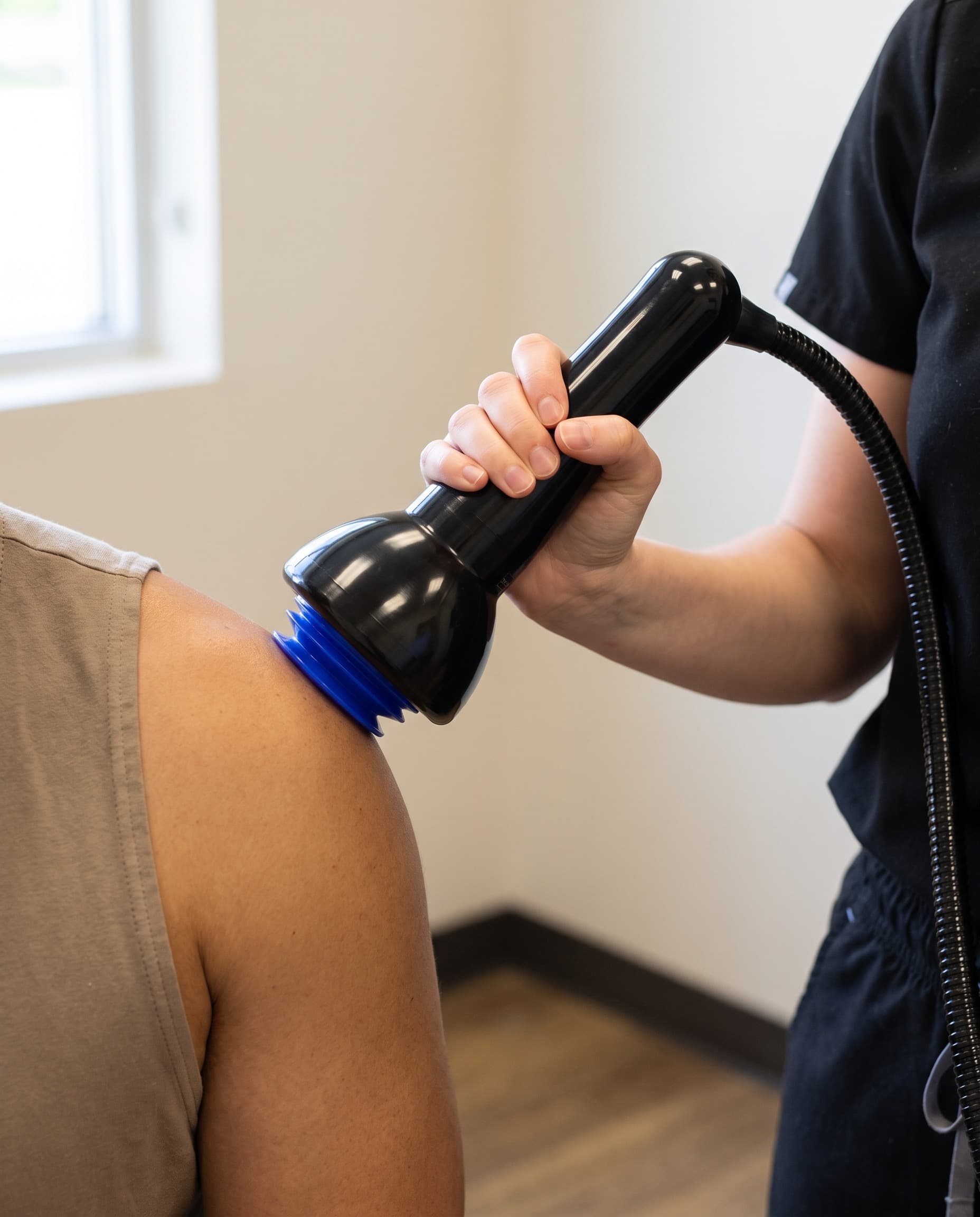 Clinician treating a patient's shoulder with QuasoniQ+™